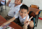 A child makes a peace sign with his hand.